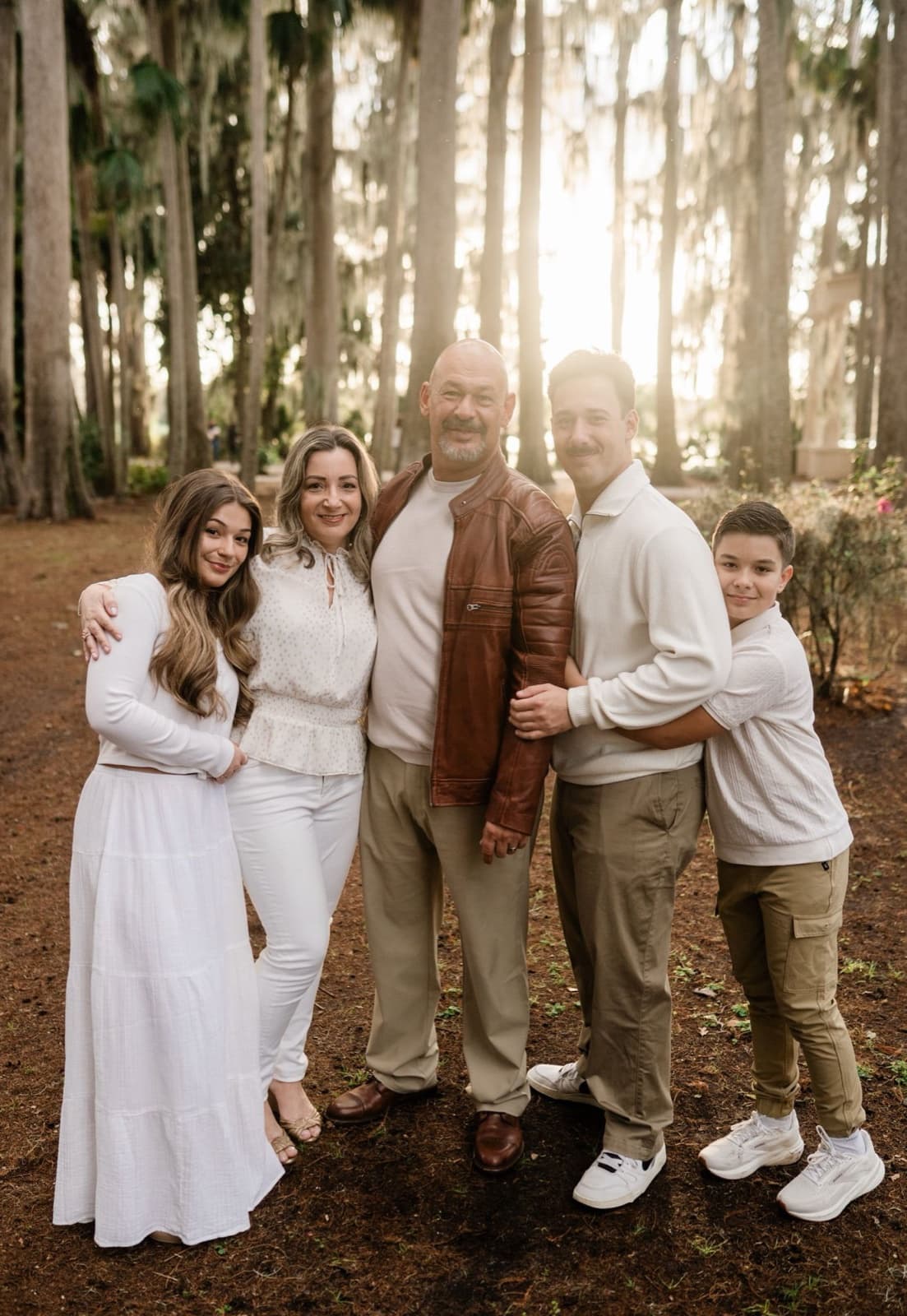 Andressa with her family gathered together in a sunlit Florida forest