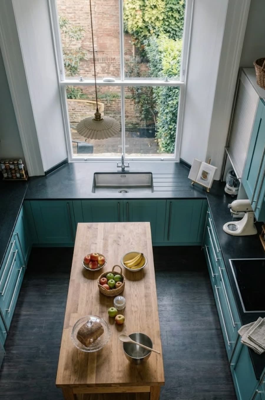 The Divine Delights kitchen in Winter Garden, Florida — top-down view of teal cabinets and a butcher-block island